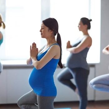 A pregnant woman in a yoga class. 