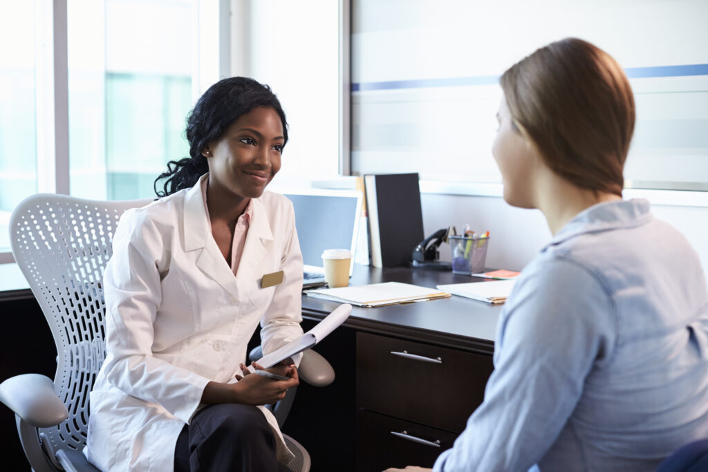 A doctor and a patient talking inside an office.